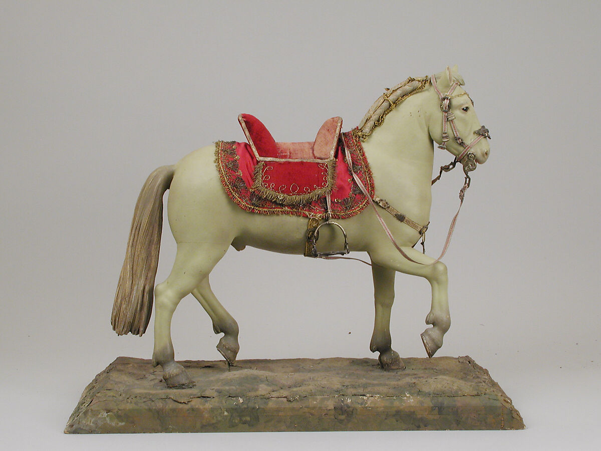 Horse, Polychromed terracotta body; wooden legs and tail; velvet covered wooden saddle; satin saddle blanket bordered with metallic thread; gold neck strap and gold threaded girth with gilt metal buckles; silver braided martingale; gold braided mane; silver braided bridle; silver stirrups and silver braided reins