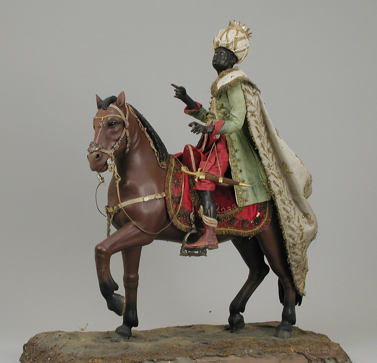 Brown horse, Polychromed terracotta body; wooden legs and tail; velvet covered wooden saddle; satin saddle blanket fringed with metallic thread; gold threaded girth with gilt buckles; silver martingale; gold braided mane and reins; silver braided bridle and silver stirrups