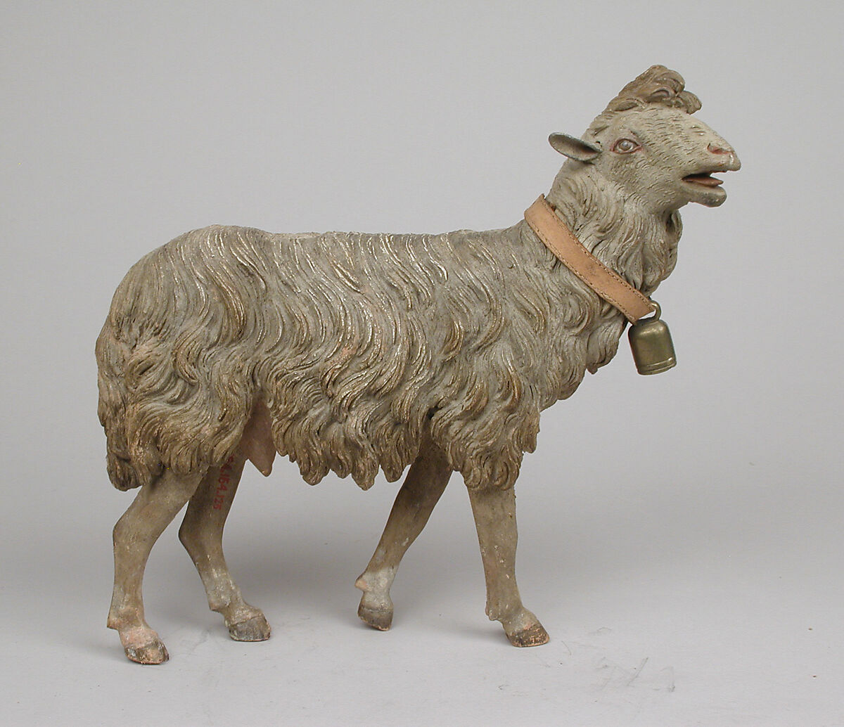 Standing sheep, Polychromed terracotta body, wooden legs, metal ears