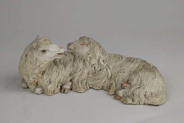 Pair of reclining sheep, Polychromed terracotta body with glass eyes