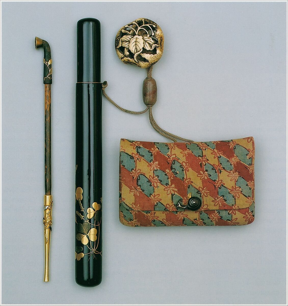 Pipe and Pipe Case with Tobacco Pouch, Shibata Zeshin, Pipe: iron, gold, and silver on wood; case: gold, silver hiramaki‑e on black lacquer; pouch: dyed cotton (sarasa) with metal fitting; netsuke: carved staghorn, Japan
