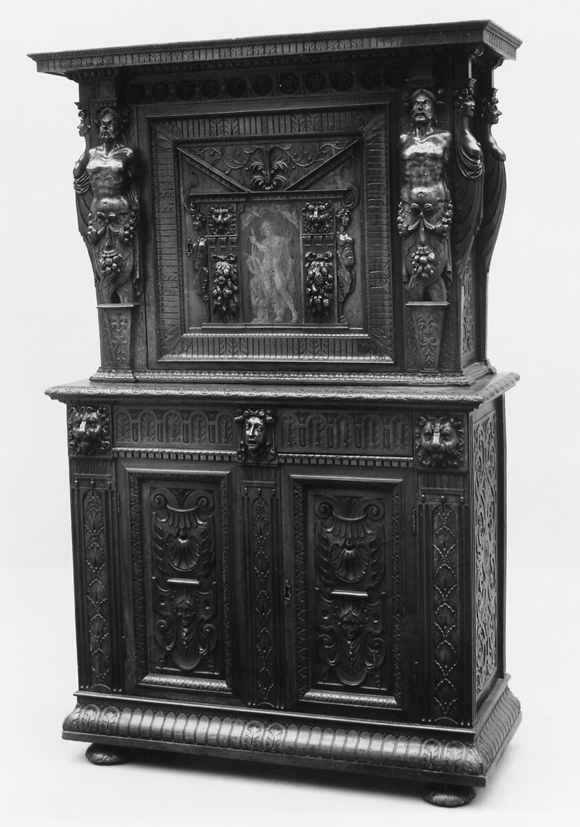 A deep wood armoire with various statue-like carvings used as columns to hold up the structure. 