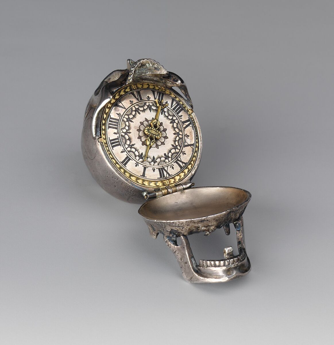 Watch in the form of a human skull, Watchmaker: Isaac Penard (Swiss, 1619–1676), Case: silver; Dial: silver, partly nielloed; Movement: gilded brass and steel, Swiss, Geneva