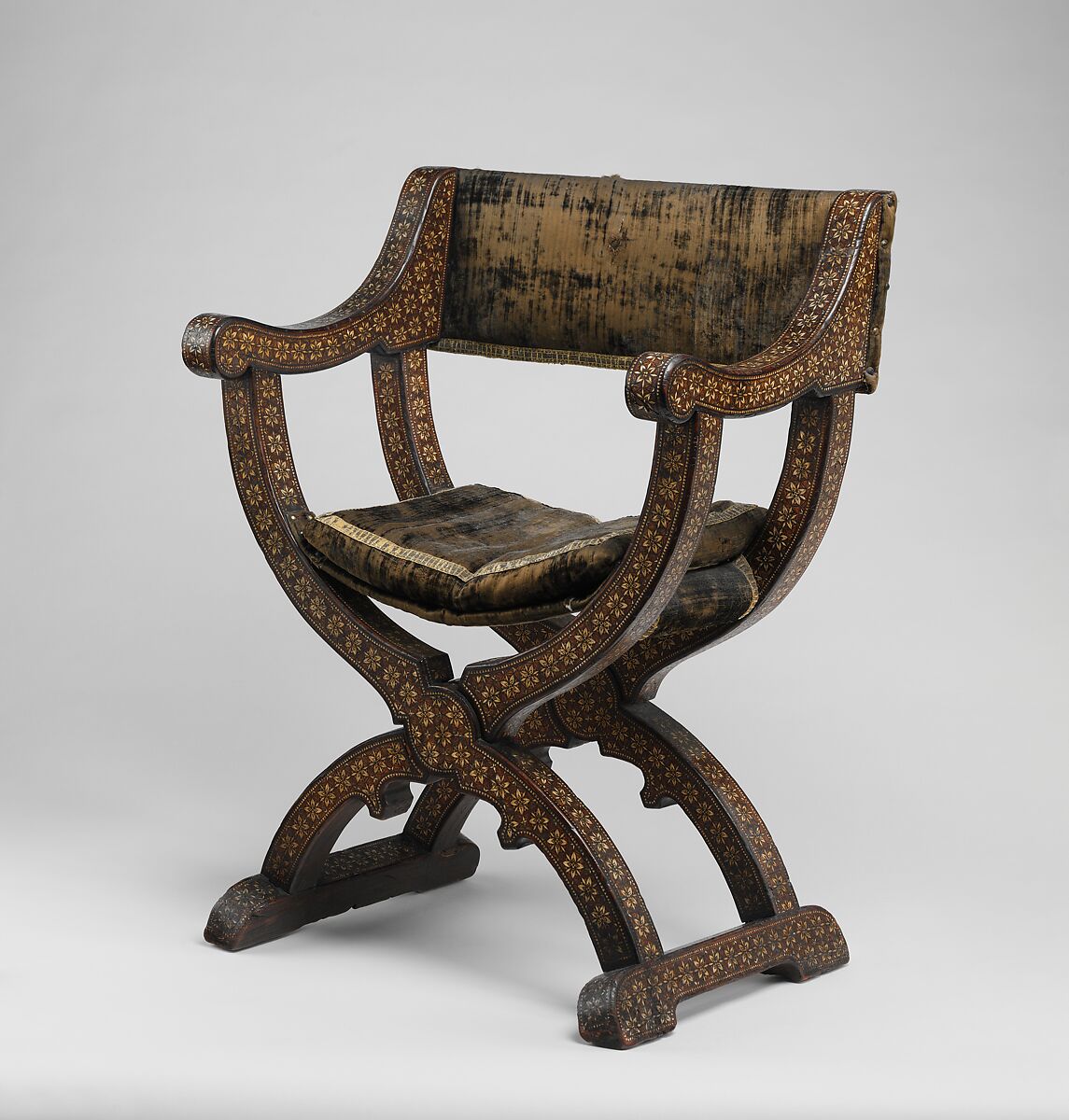 Hip-joint armchair (sillón de cadera or jamuga), Walnut and elm, partly veneered and inlaid with different woods, ivory, bone (camel?) and pewter; covered in silk velvet not original to the armchair, Spanish, Granada 