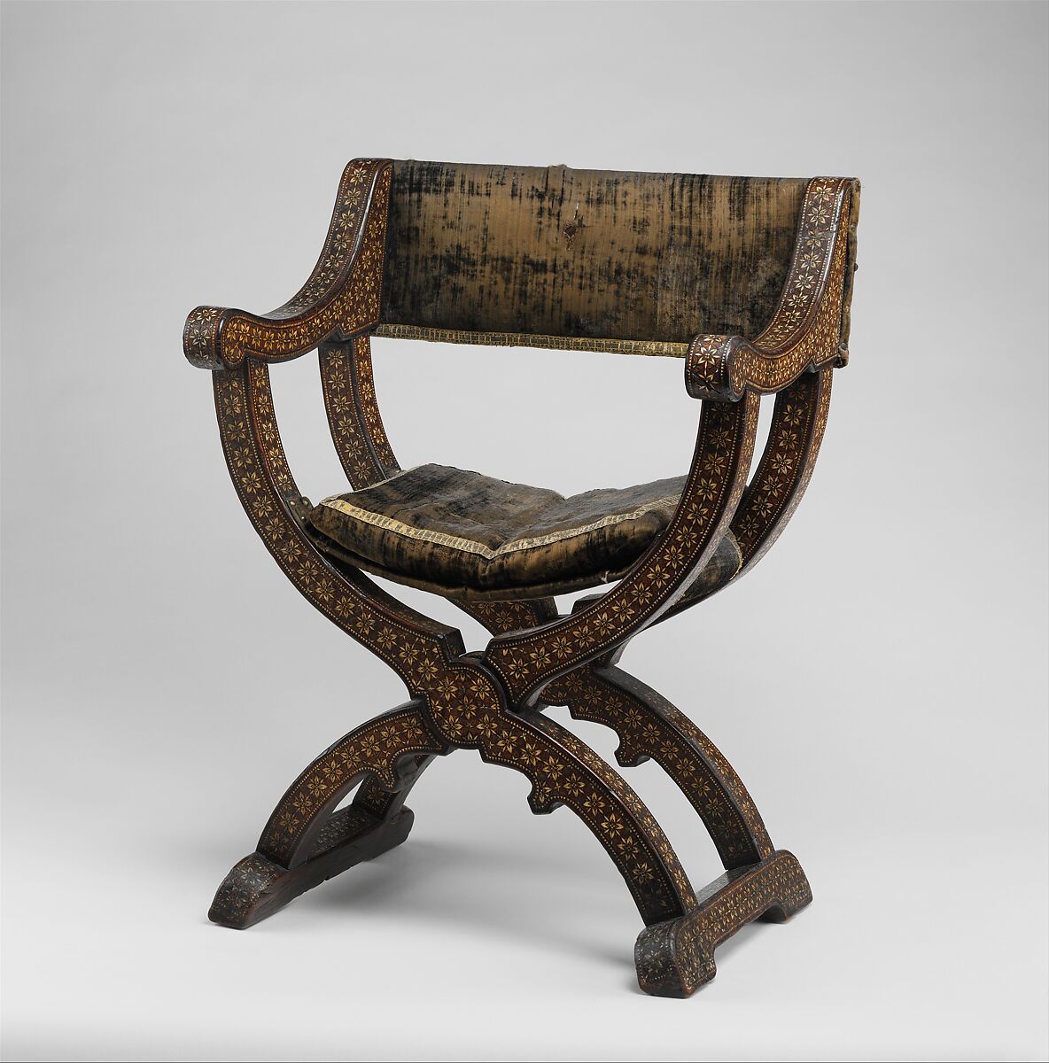 Hip-joint armchair (sillón de cadera or jamuga), Walnut and elm, partly veneered and inlaid with different woods, ivory, bone (camel?) and pewter; covered in silk velvet not original to the armchair, Spanish, Granada