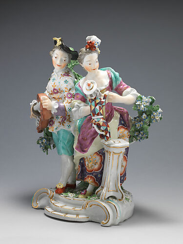 Youth playing hurdy-gurdy, girl teaching dog dressed as harlequin to dance