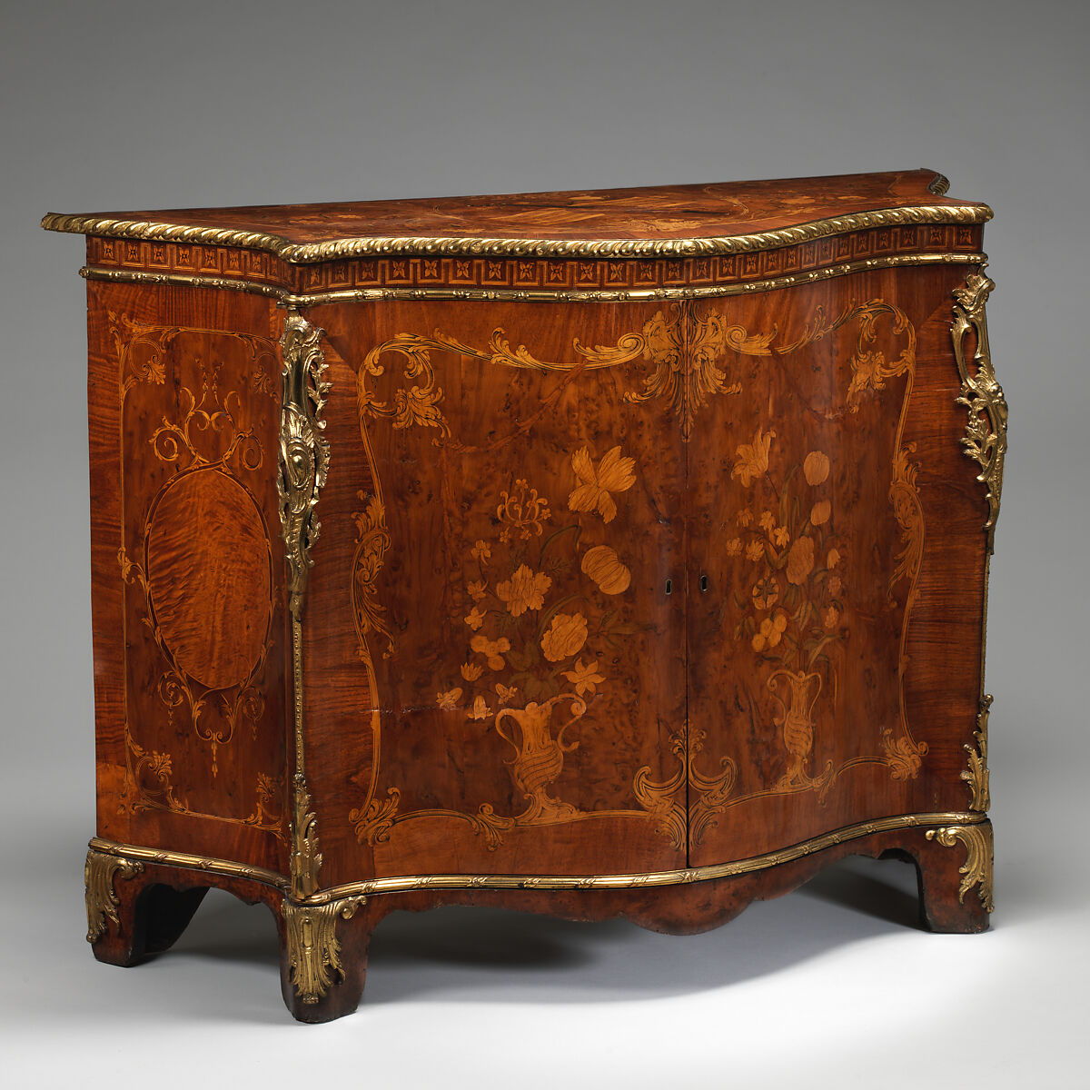 Commode, Attributed to John Mayhew (British, 1736–1811), Pine veneered with satinwood, mahogany, burl, yew, and purplewood; gilt bronze, British 