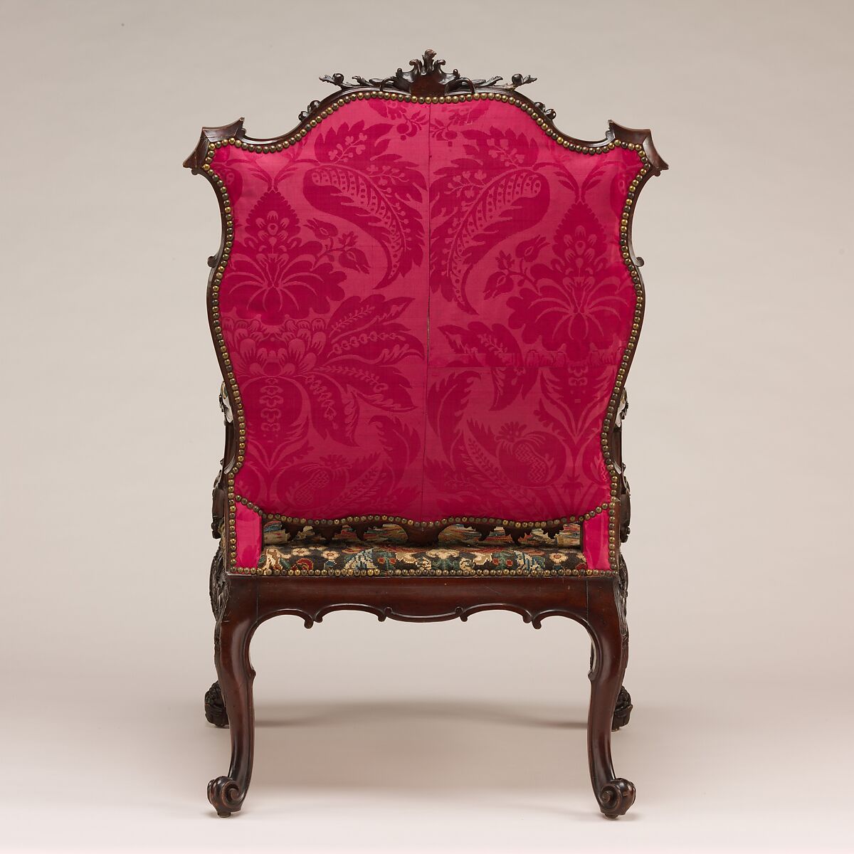 Armchair, After a design by Thomas Chippendale. The back of the chair is seen with a vibrant pink upholstery. 
