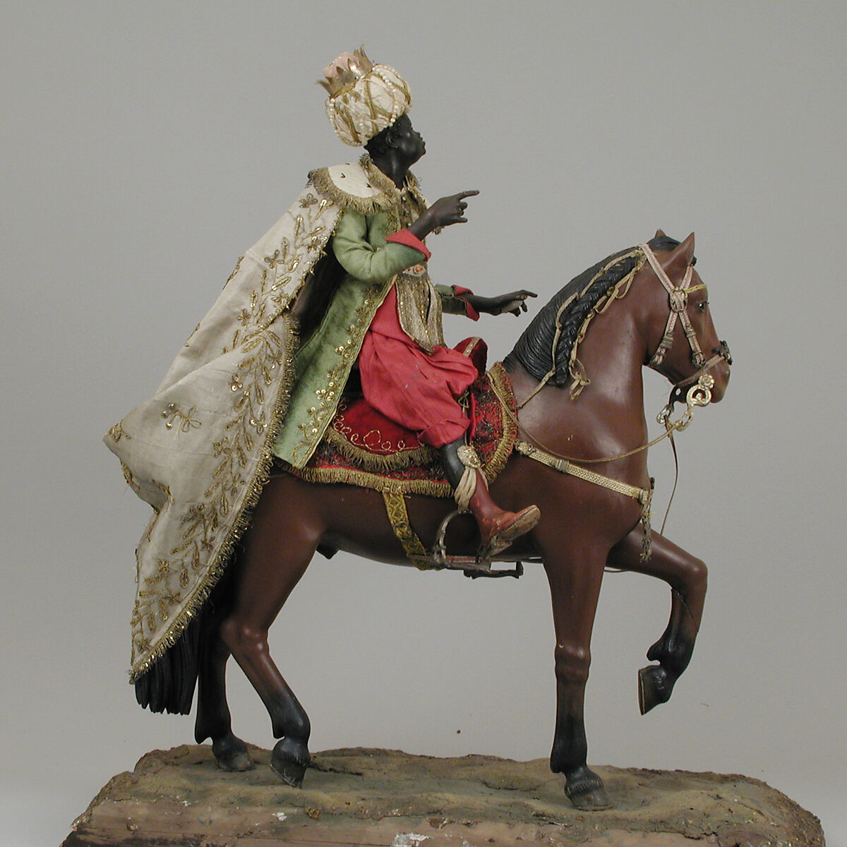 Brown horse, Polychromed terracotta body; wooden legs and tail; velvet covered wooden saddle; satin saddle blanket fringed with metallic thread; gold threaded girth with gilt buckles; silver martingale; gold braided mane and reins; silver braided bridle and silver stirrups, Italian, Naples
