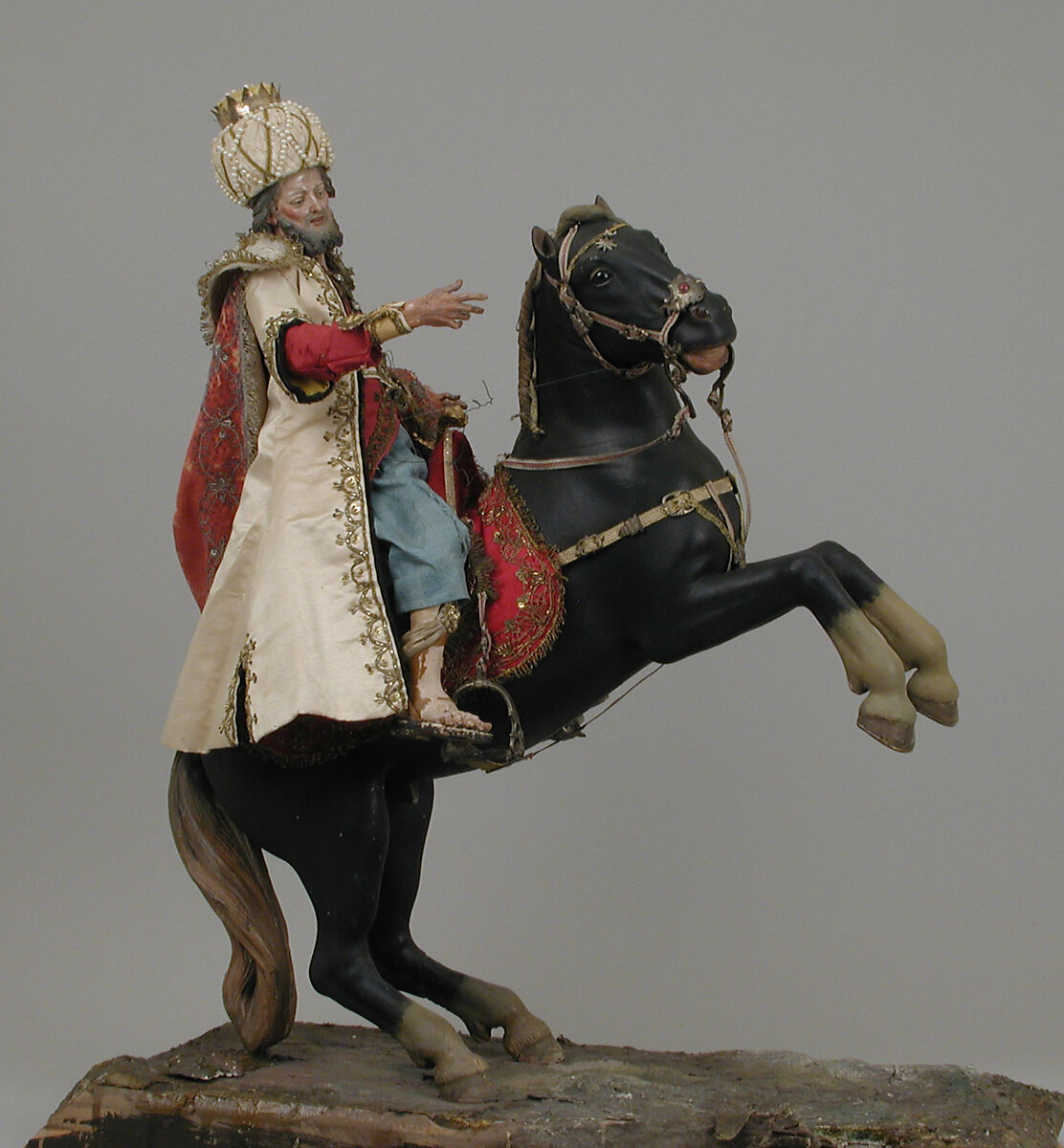 Black horse, Polychromed terracotta body; wooden legs and tail; velvet covered wooden saddle; satin saddle blanket with metallic thread; gold braided girth and neck strap with silver buckles; silver braided martingale, bridle and reins; gold braided mane; silver stirrups, Italian, Naples 