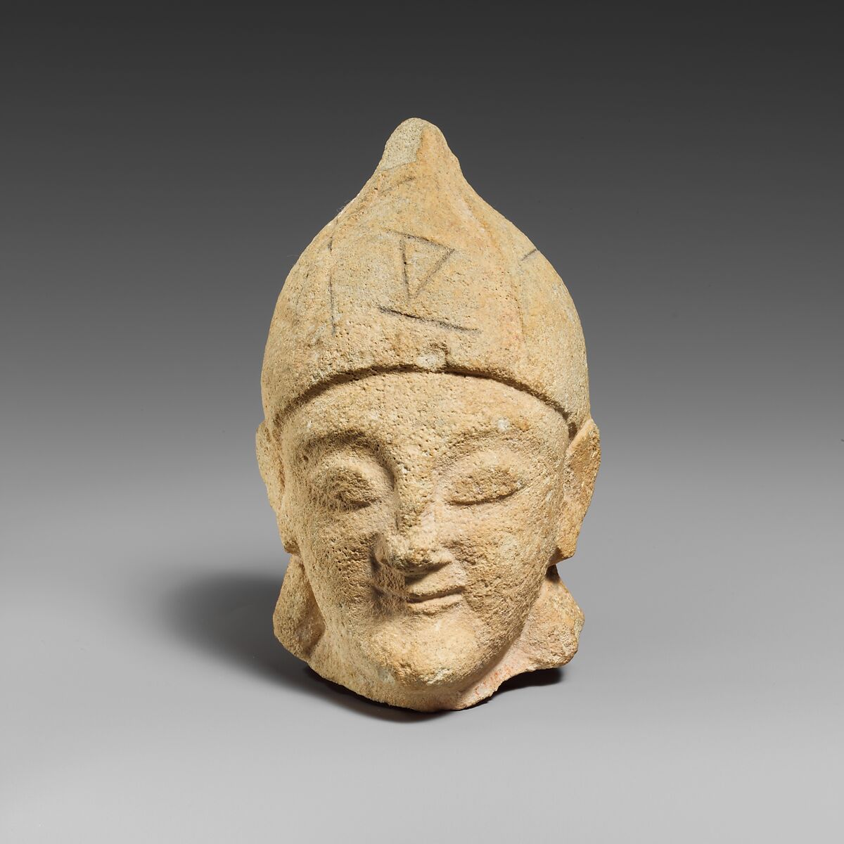 Limestone head of a beardless male with a helmet of Greek type, Limestone, Cypriot 