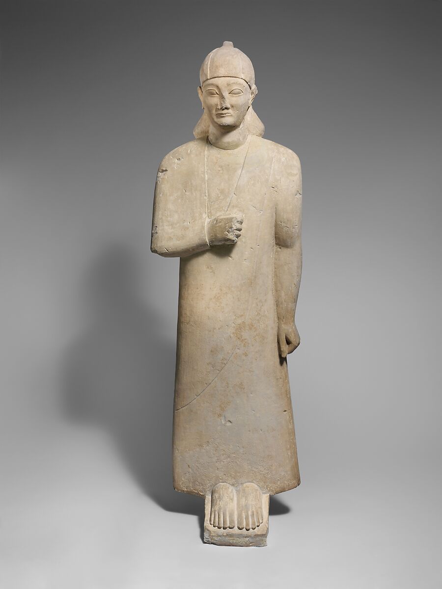 Limestone votary of a beardless male wearing a long garment and a conical helmet, Limestone, Cypriot 