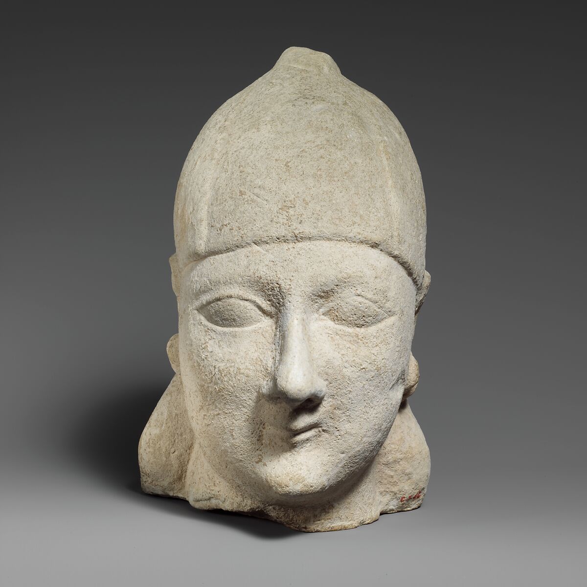 Limestone head of a beardless male wearing a conical helmet, Limestone, Cypriot