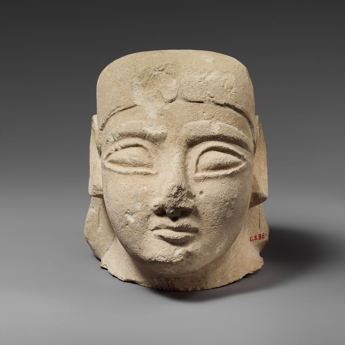 Limestone head of a beardless male with a plain headdress, Limestone, Cypriot 