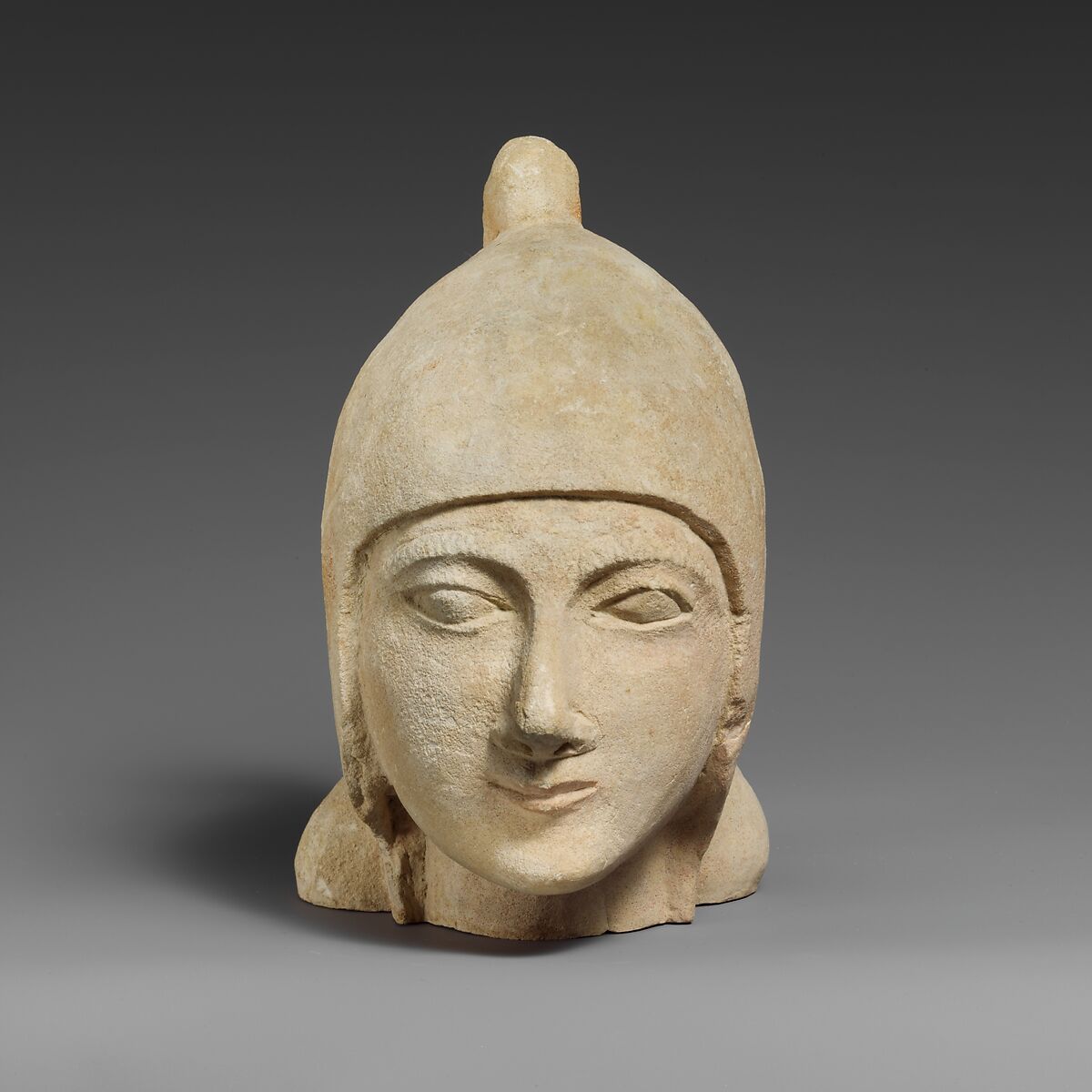 Limestone head of a beardless male wearing a conical helmet, Limestone, Cypriot 