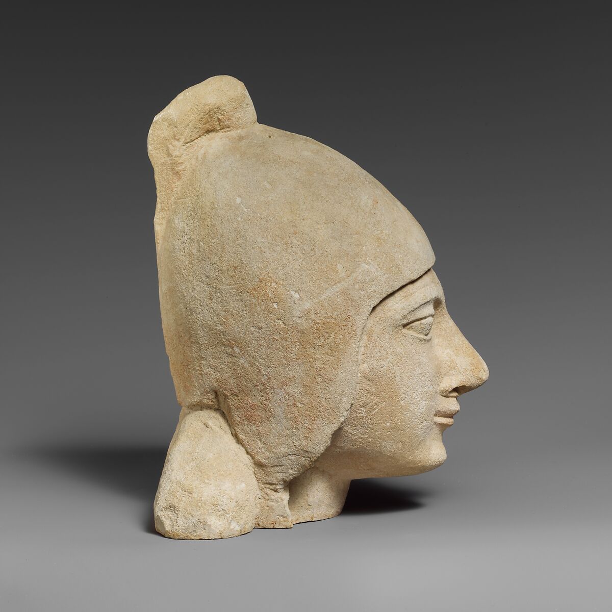 Limestone head of a beardless male wearing a conical helmet, Limestone, Cypriot