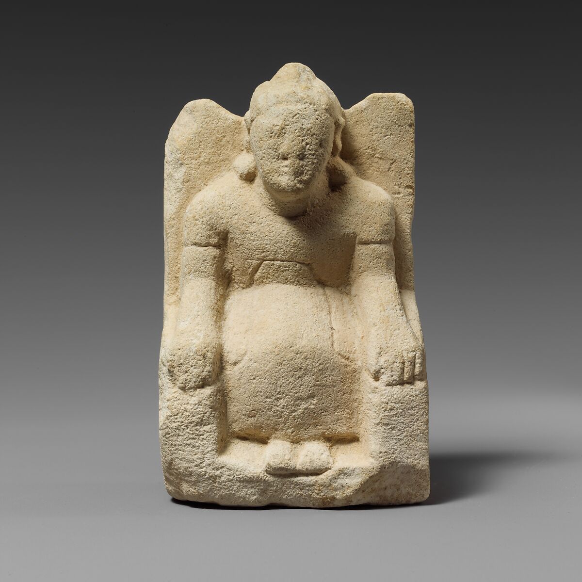 Limestone statuette of a seated beardless male votary with a helmet, Limestone, Cypriot 