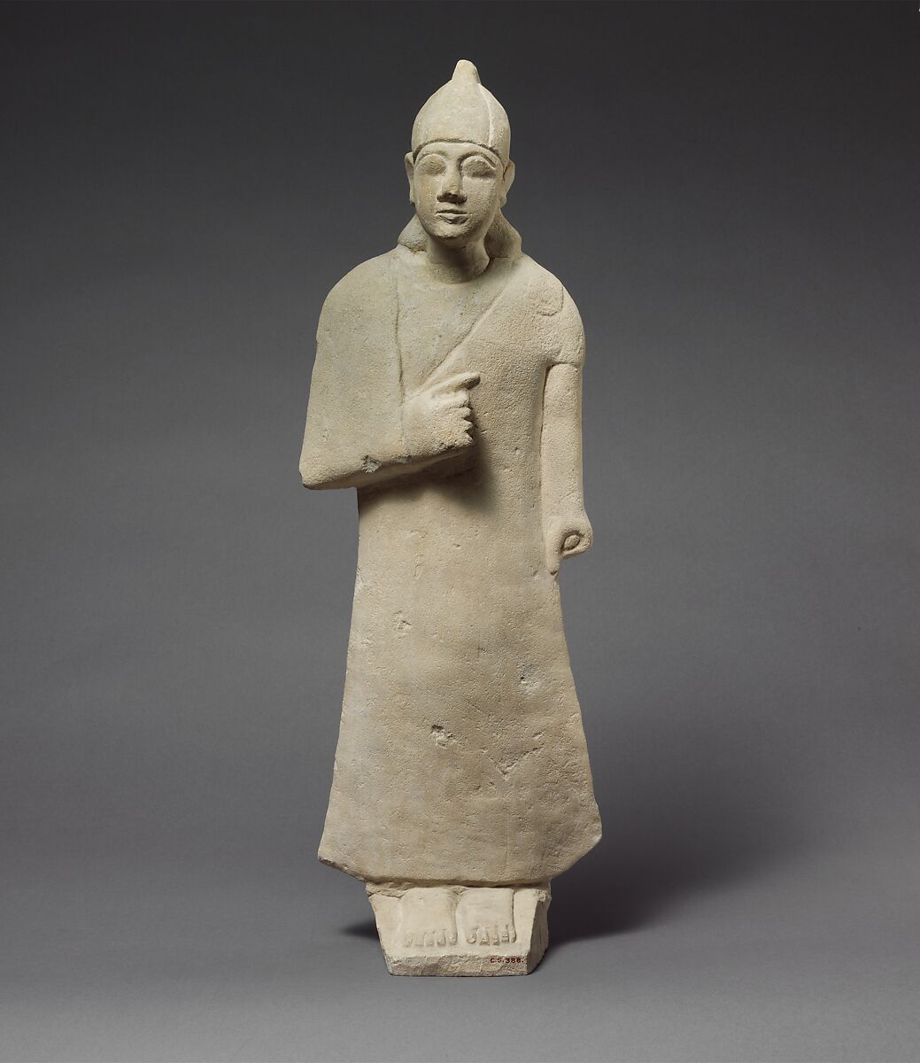 Statuette of a beardless male votary wearing a long garment and a conical helmet, Limestone, Cypriot 