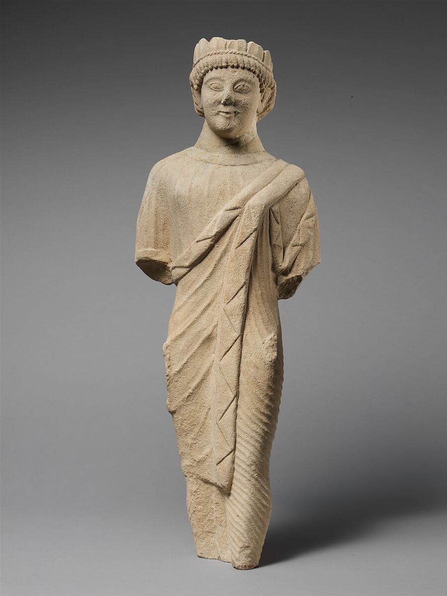 Limestone statuette of a beardless male votary in Greek dress with a wreath of leaves, Limestone, Cypriot 