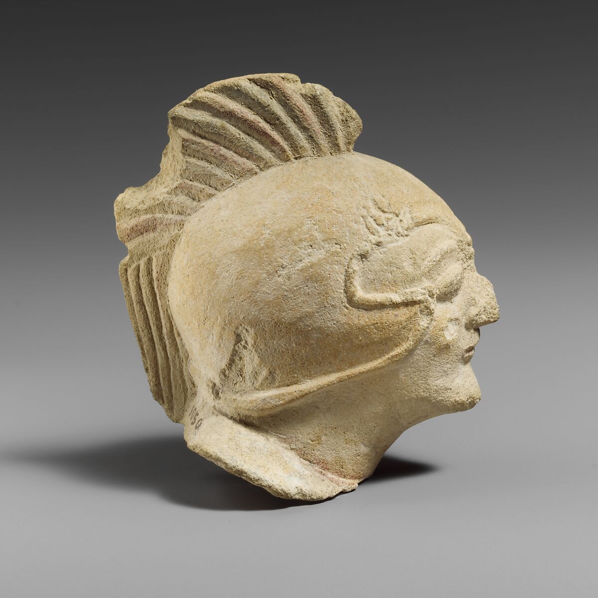 Limestone head of a beardless male with a helmet of Greek type, Limestone, Cypriot