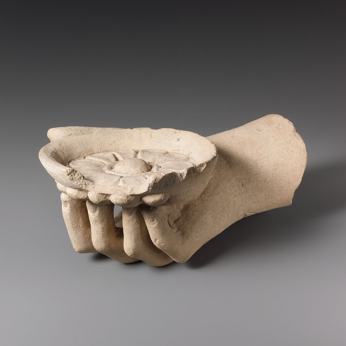 Limestone hand holding a phiale (libation bowl), Limestone, Cypriot 