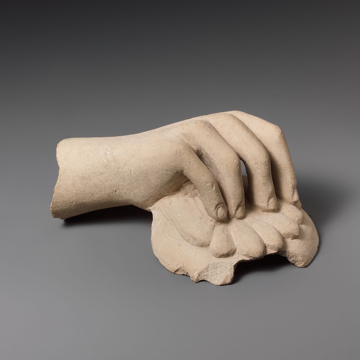Limestone hand holding a phiale (libation bowl), Limestone, Cypriot