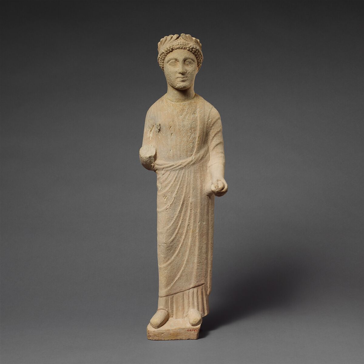 Limestone statuette of a beardless male votary with a wreath of leaves, Limestone, Cypriot 