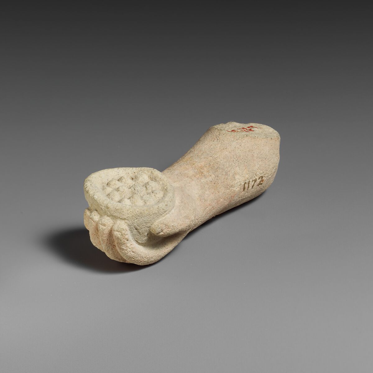 Limestone arm with pieces of fruit (?) held in the hand, Limestone, Cypriot 