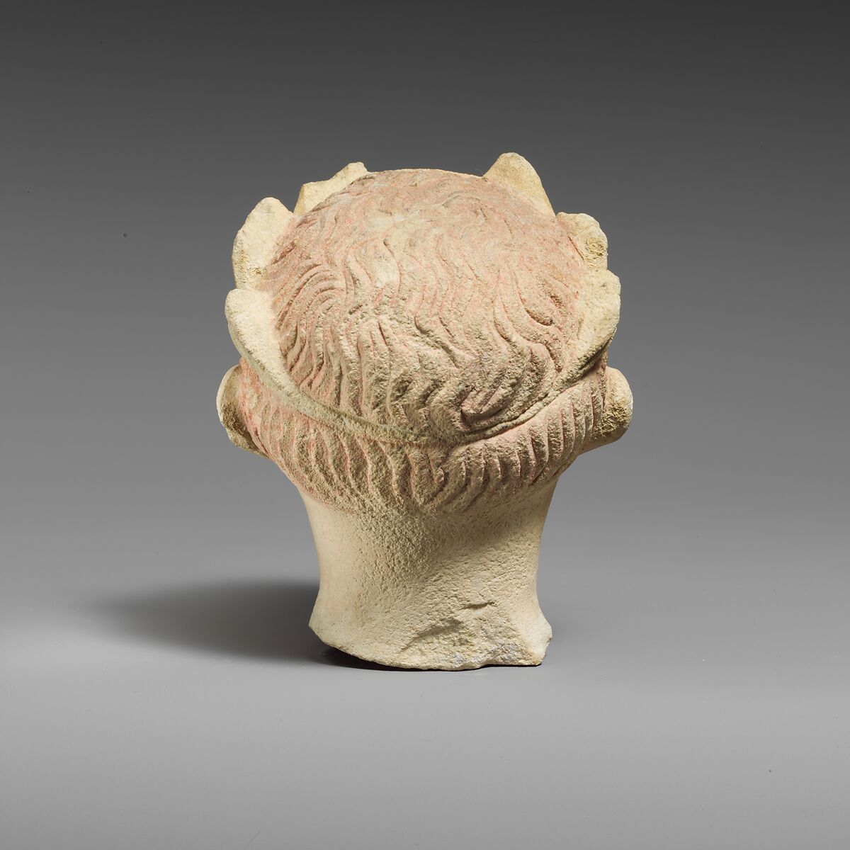 Limestone head of a boy with a wreath of leaves, Limestone, Cypriot