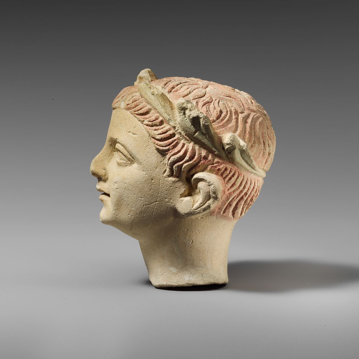 Limestone head of a boy with a wreath of leaves, Limestone, Cypriot