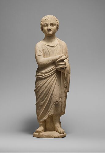 Limestone statue of a youth holding a pyxis
