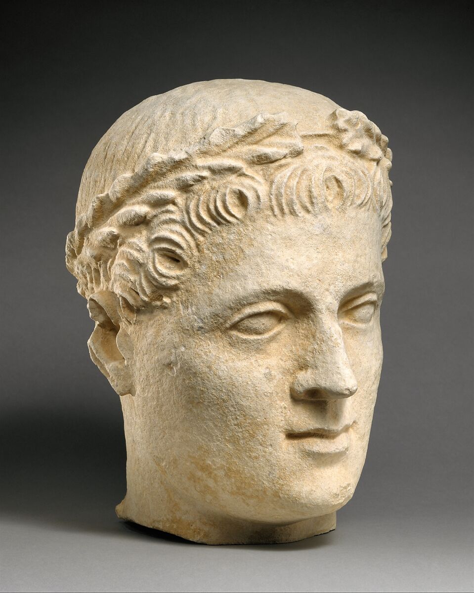 Limestone head of beardless male votary with wreath of leaves, Limestone, Cypriot 