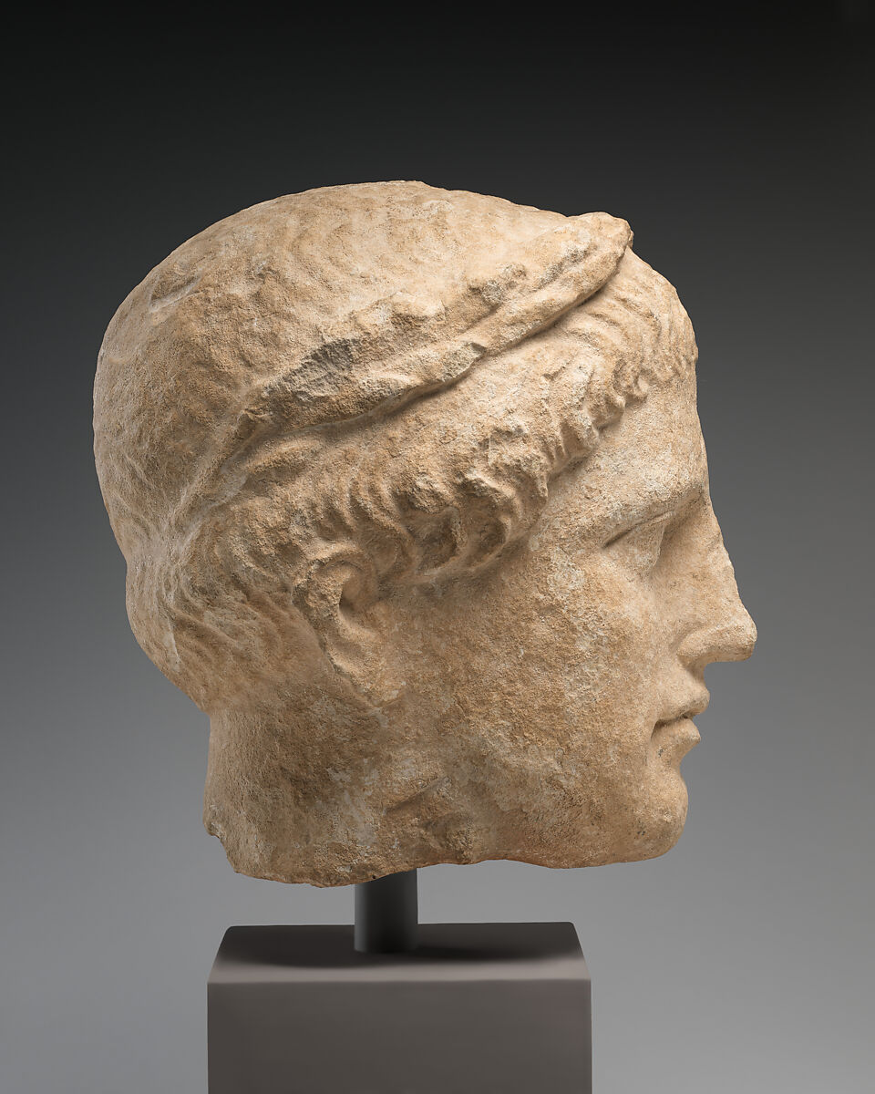 Limestone head of beardless male votary with wreath of leaves, Limestone, Cypriot