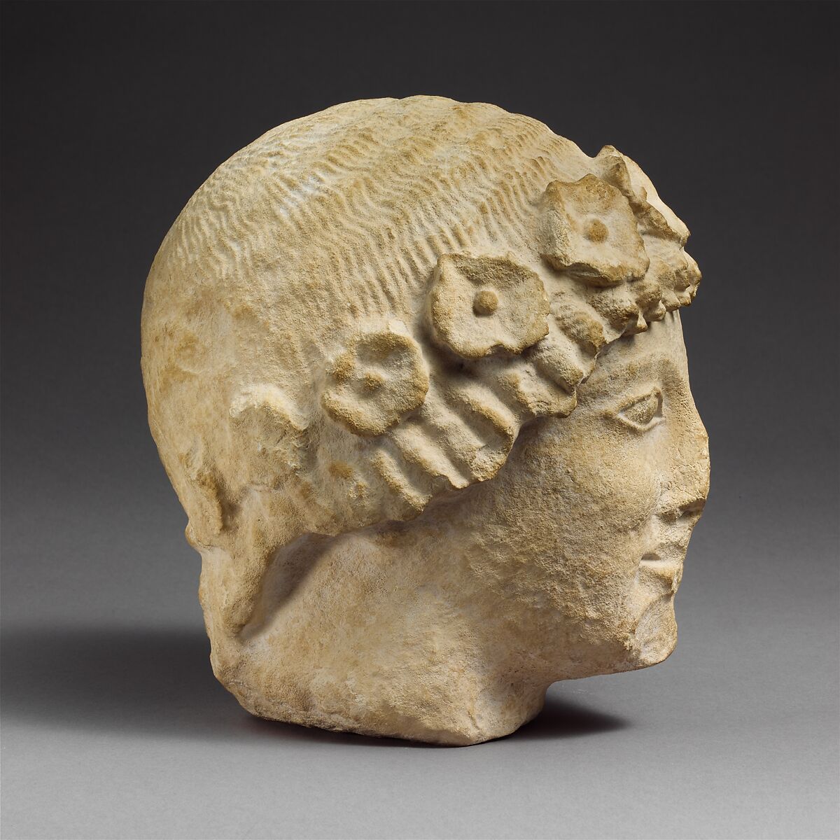 Limestone beardless male head with a wreath of rosettes, Limestone, Cypriot