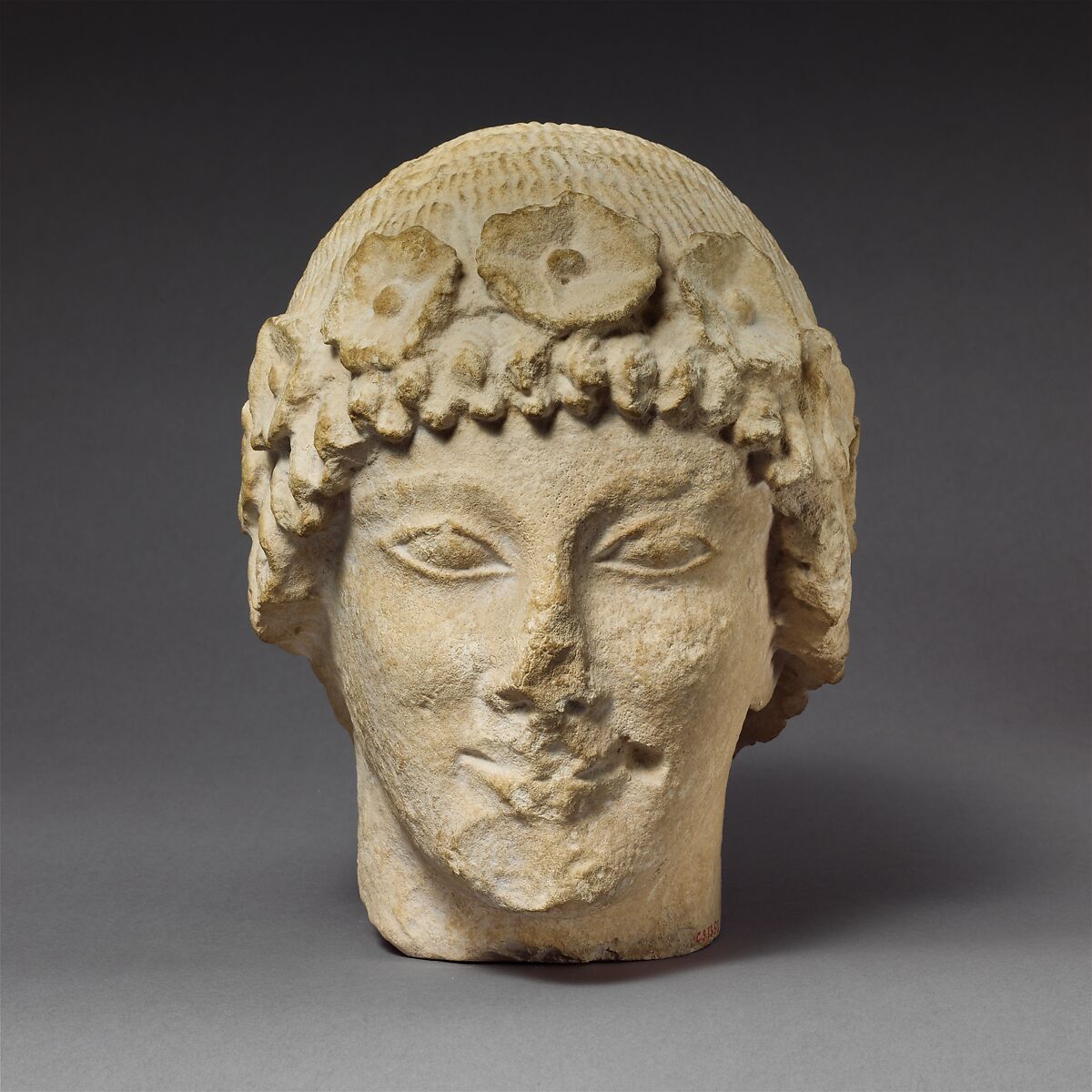 Limestone beardless male head with a wreath of rosettes, Limestone, Cypriot 