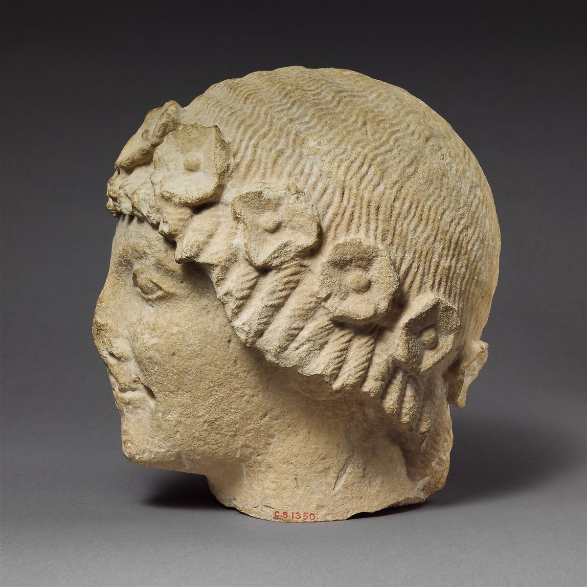 Limestone beardless male head with a wreath of rosettes, Limestone, Cypriot