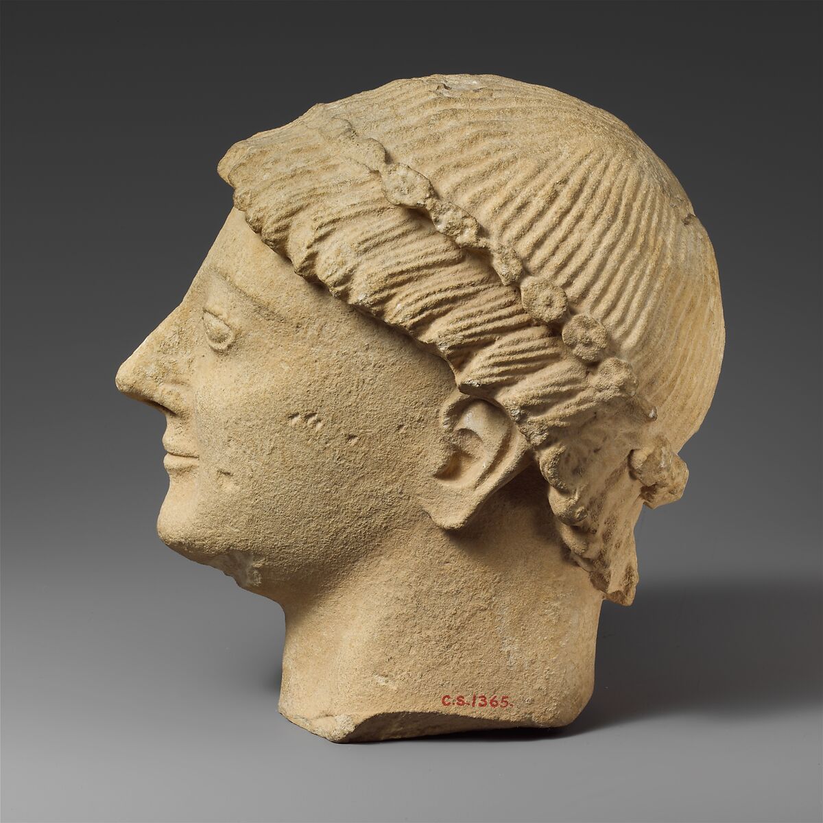 Limestone head of a beardless male votary with a wreath of rosettes, Limestone, Cypriot