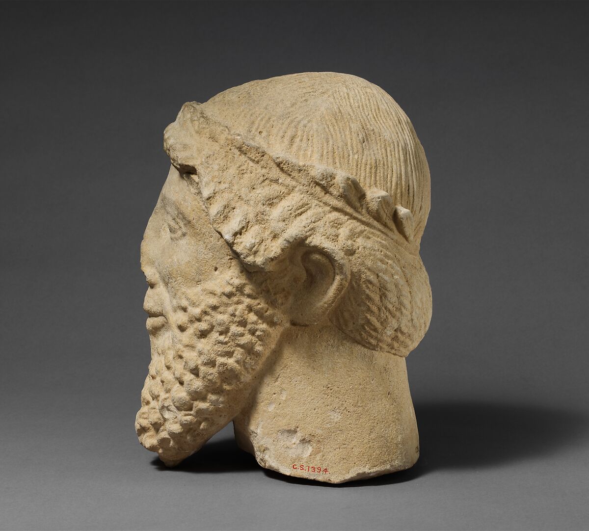 Limestone head of a bearded male with a wreath of leaves, Limestone, Cypriot