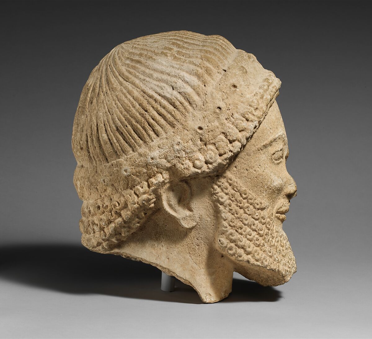 Limestone head of a bearded male with a wreath of flowers, Limestone, Cypriot