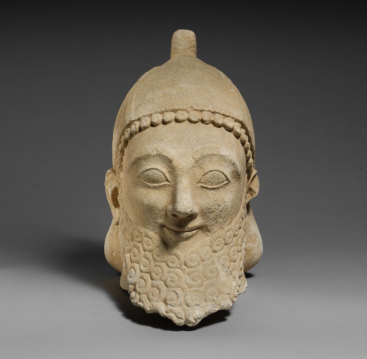 Limestone head of a bearded male wearing a conical helmet, Limestone, Cypriot 