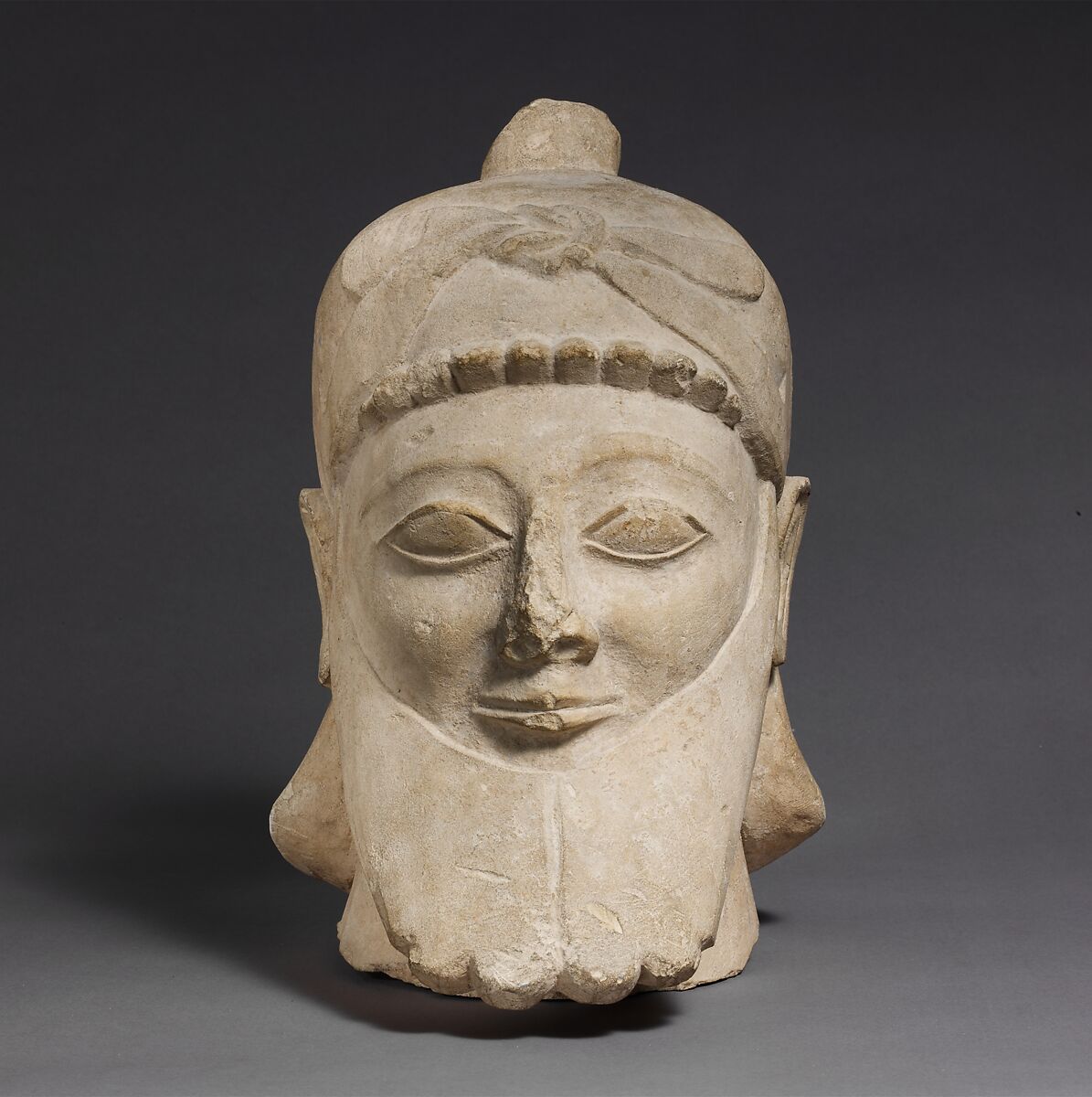 Limestone head of a bearded male wearing a conical helmet, Limestone, Cypriot 