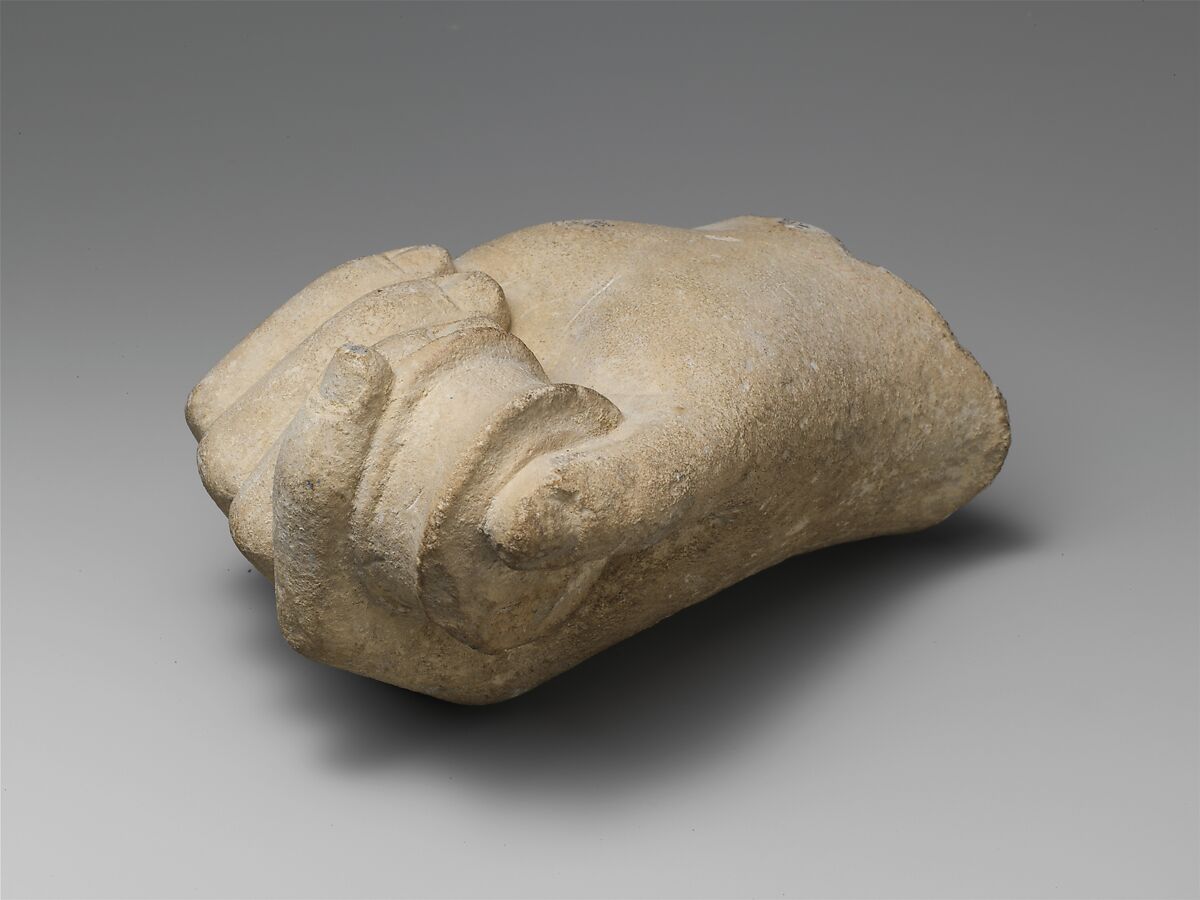 Limestone statue fragment of a hand holding a pyxis or bobbin, Limestone, Cypriot 