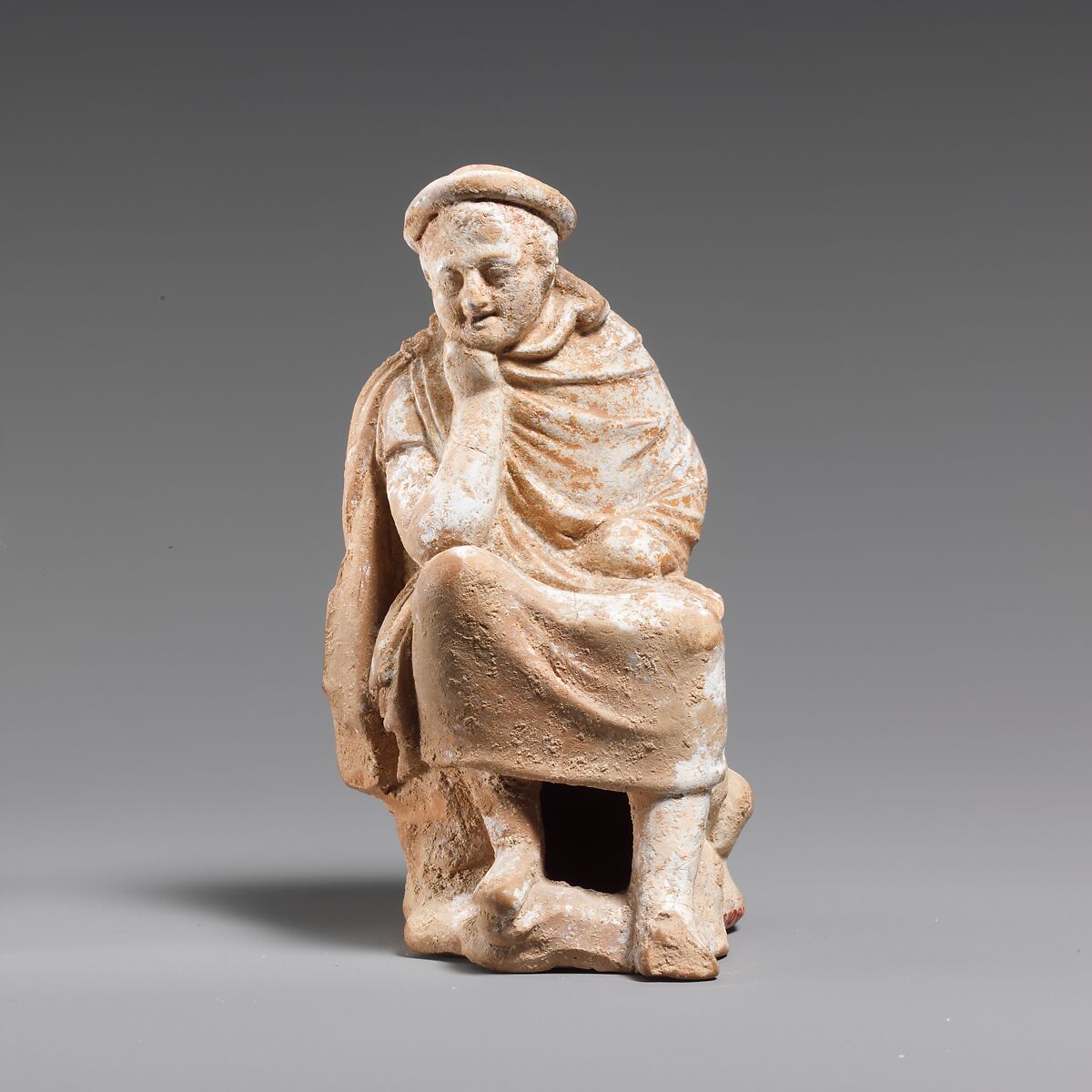 Terracotta statuette of a youth seated on a rock, Terracotta, Greek, Boeotian 