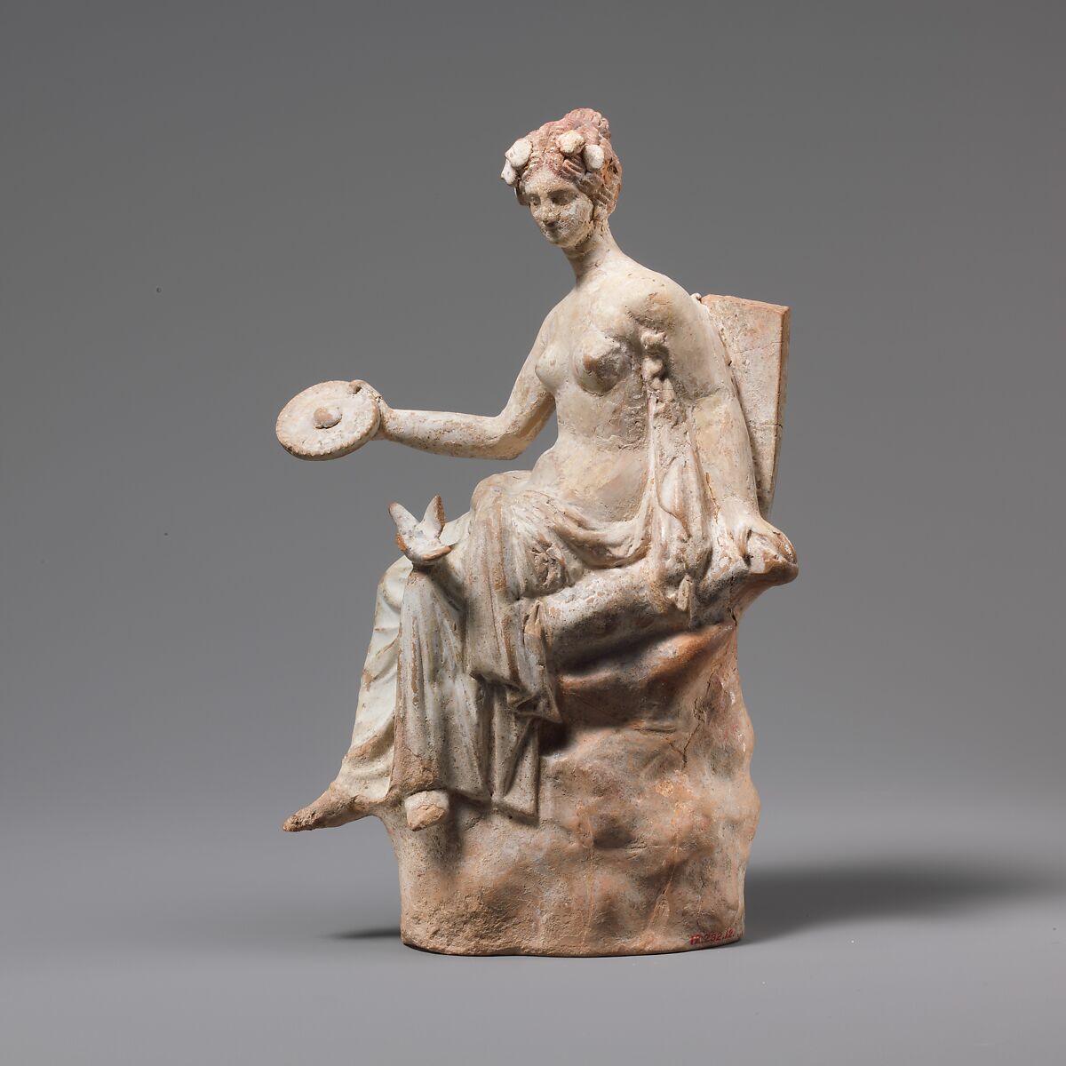 Terracotta statuette of Aphrodite seated on a rock, Terracotta, Greek, South Italian 