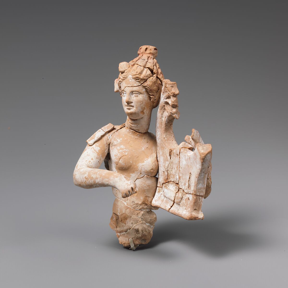 Fragmentary terracotta statuette of a woman with a kithara, Terracotta, Greek, South Italian, Tarentine 