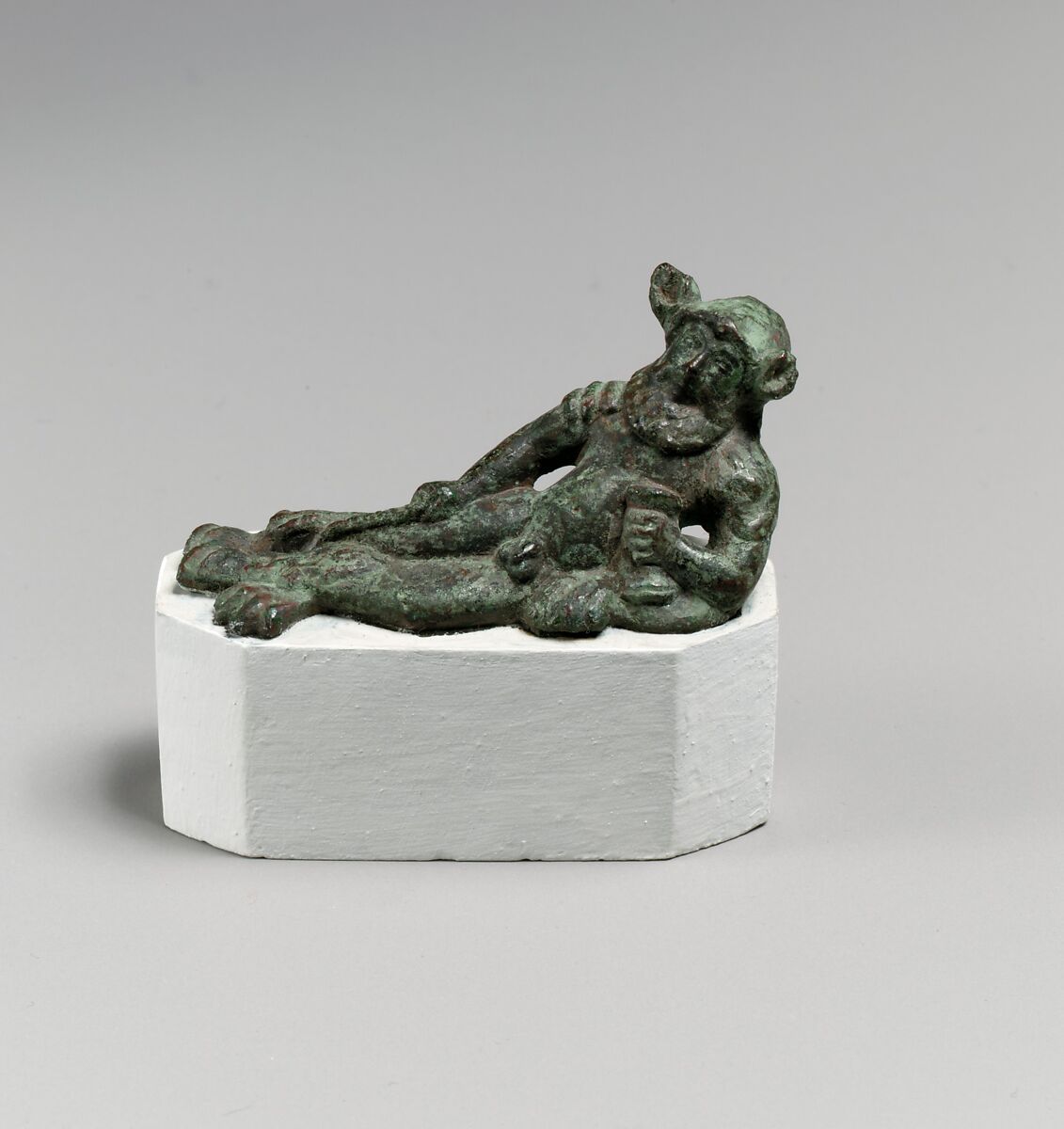 Bronze statuette of a satyr reclining on a lion's skin, Bronze, Etruscan 