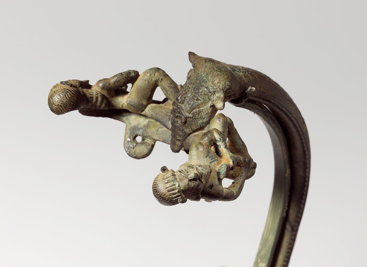 Bronze oinochoe (jug) handle with satyrs flanking a head of Acheloos, Bronze, Etruscan