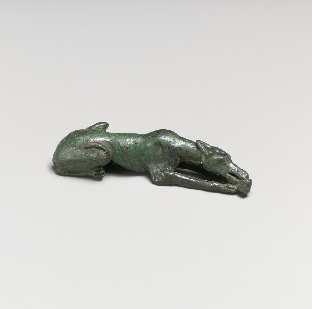Bronze statuette of a hound gnawing a bone, Bronze, Greek 