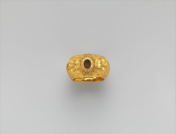 Gold ring with embossed satyr masks: on carnelian intaglio, bird