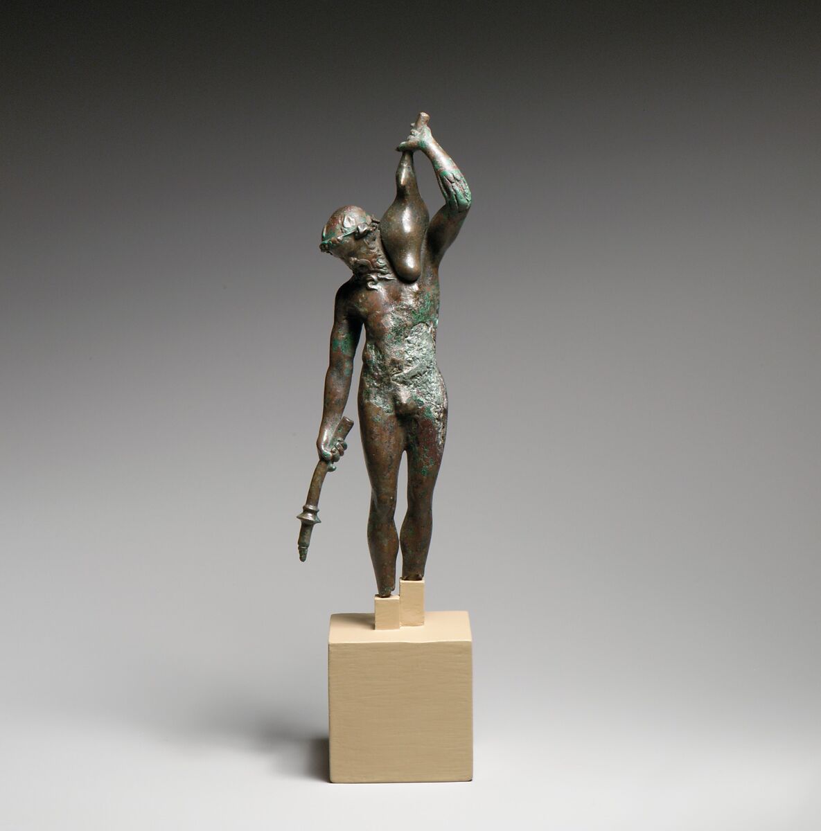 Bronze statuette of a satyr with a torch and wineskin, Bronze, Greek